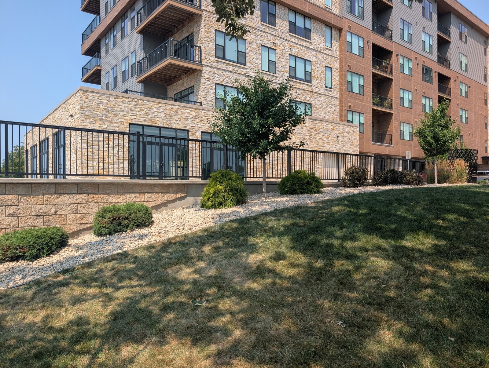 Rock beds and shrubs along the retaining wall of an apartment building