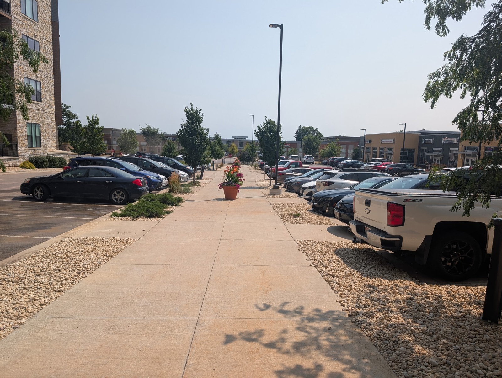 Rock beds along a parking lot sidewalk at an apartment complex