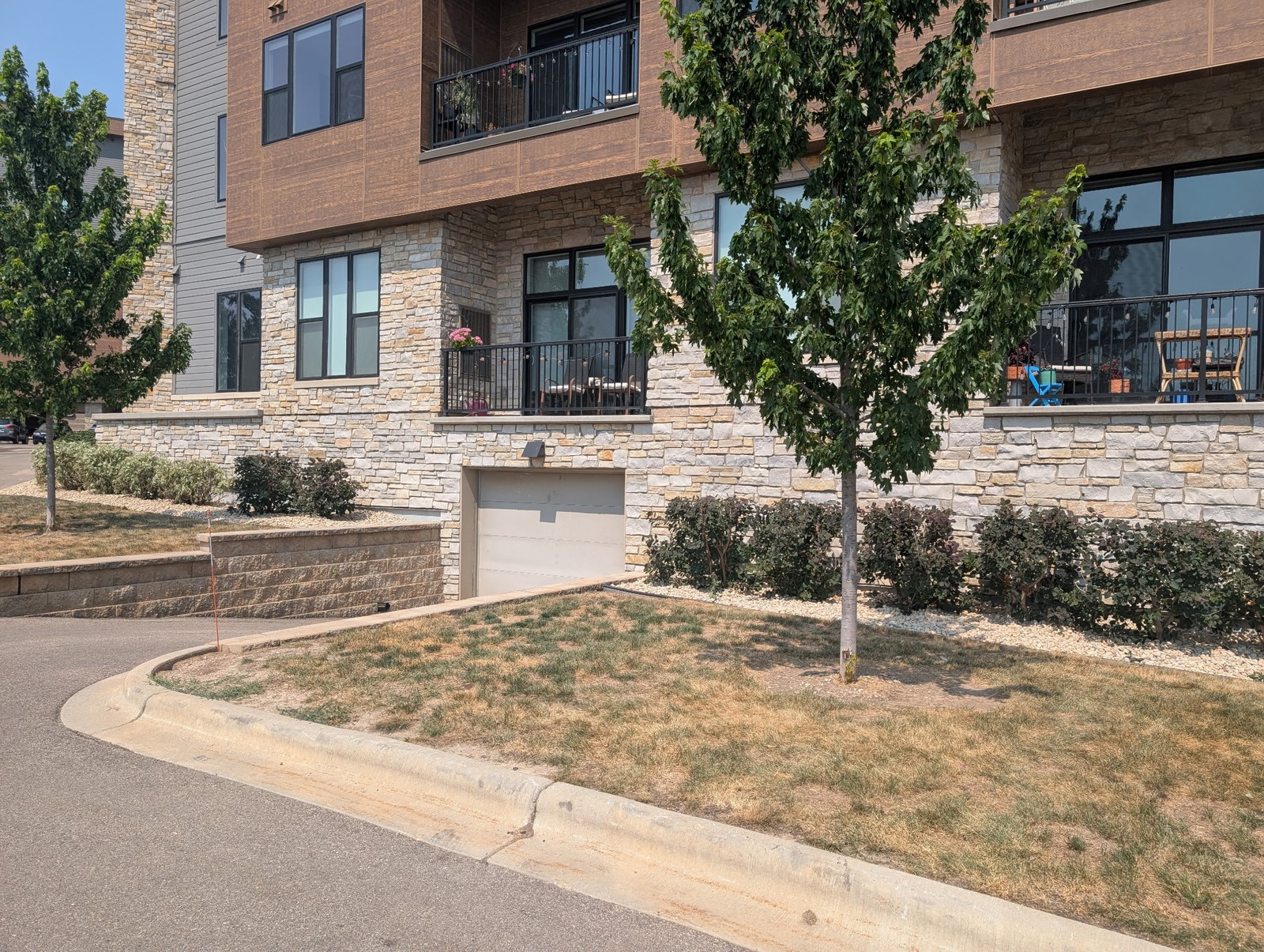 Shrub bed along the stone base of an apartment building