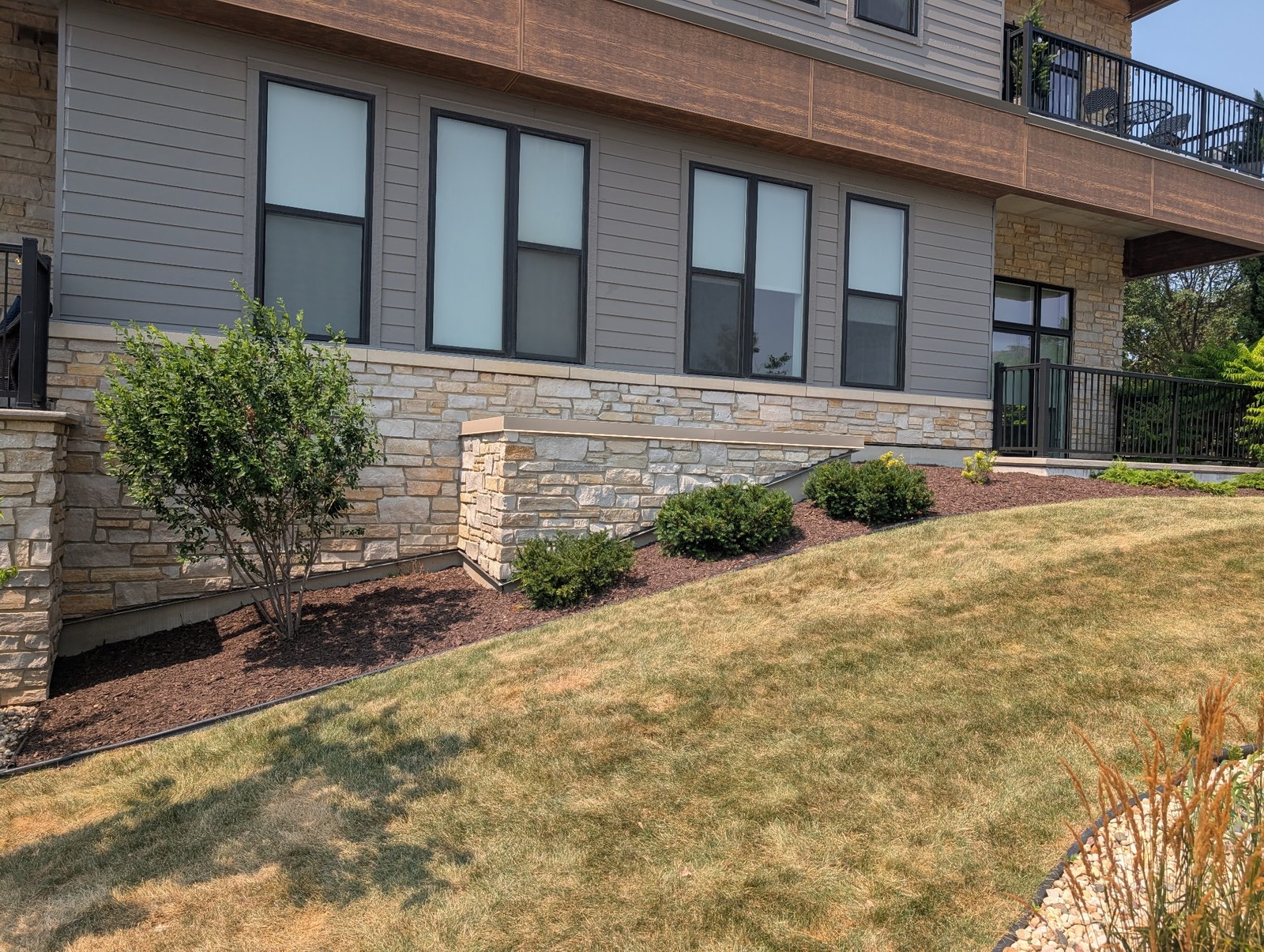 Mulch bed with shrubs along an apartment building