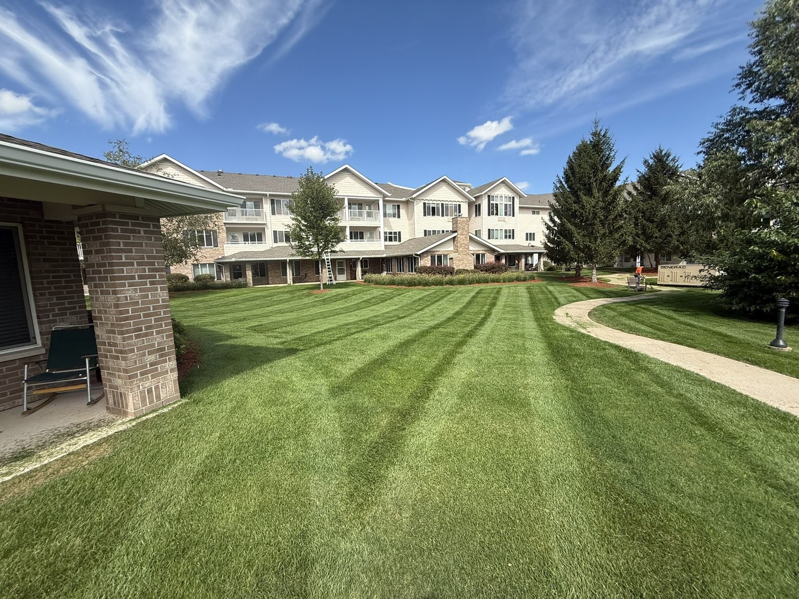 Striped courtyard lawn at an apartment building with a curving walkway
